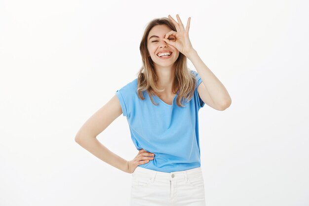 Carefree beautiful woman showing okay, no problem gesture