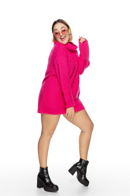 Беззаботный. Красивая молодая женщина ярко-розовый удобный свитер, изолированный длинный рукав