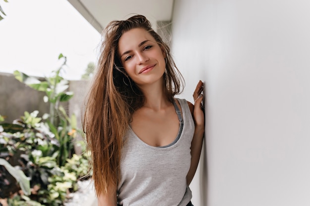 Carefree caucasian girl with trendy hairstyle smiling in morning. Wonderful young woman enjoying weekend.