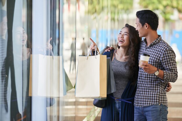 Carefree couple window shopping in the clothes store