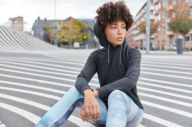 Free photo carefree ethnic young woman wears casual sweatshirt with hood