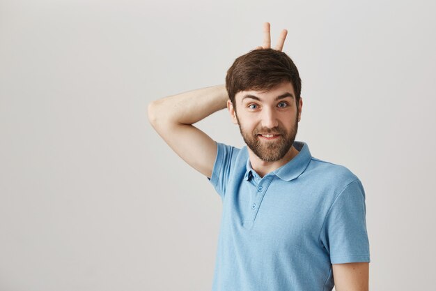 Carefree funny and cute young bearded man posing