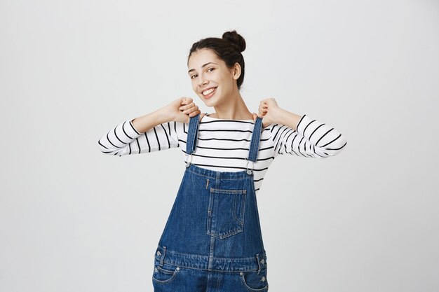 Carefree girl in denim overalls feeling joyful