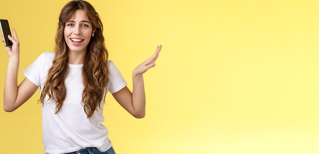 Free photo carefree goodlooking lively sociable curlyhaired girl having fun wearing wireless earbuds dancing