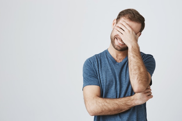 Free photo carefree happy guy laughing over joke, chuckle and close eyes