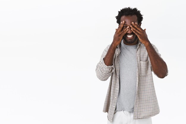 Carefree, happy smiling african-american bearded man in casual outfit, fool around, joking and laughing