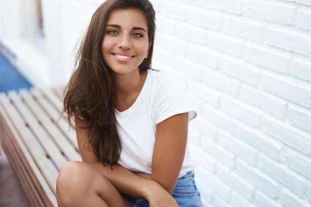 Carefree happy smiling hispanic young tanned brunette girl sit o