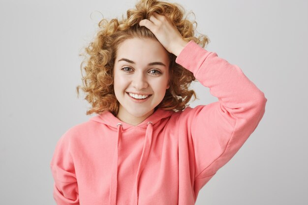 Free photo carefree happy teenage girl laughing, touching hair