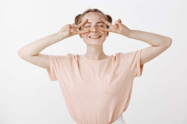 Carefree happy teenage girl posing against the white wall