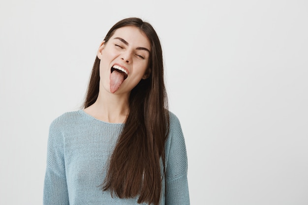 Carefree happy woman showing tongue silly