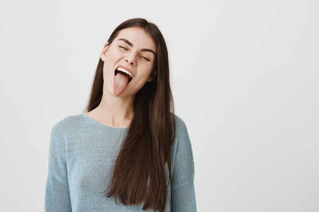 Carefree happy woman showing tongue silly