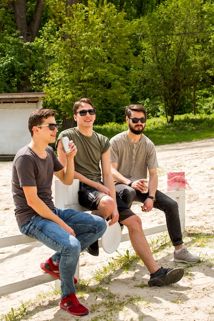 Carefree men enjoying drinks on beach