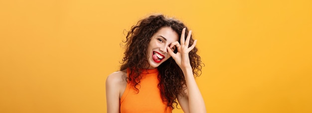 Free photo carefree optimistic and energized goodlooking woman with curly hairstyle tilting head and sticking o