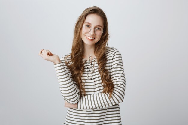 Carefree smiling girl in glasses looking pleased