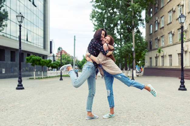 Carefree smiling sisters hugging and having fun together