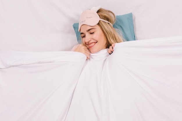 Carefree smiling woman lying in bed