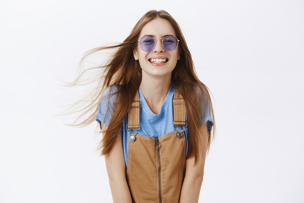 Foto gratuita ragazza alla moda spensierata in occhiali da sole sorridendo e ridendo