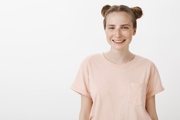 Carefree teenage girl posing against the white wall