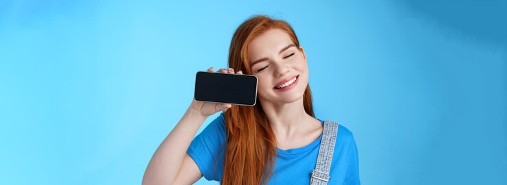 Free Photo carefree tender redhead european female tilt head smiling closed eyes hold smartphone horizontally s