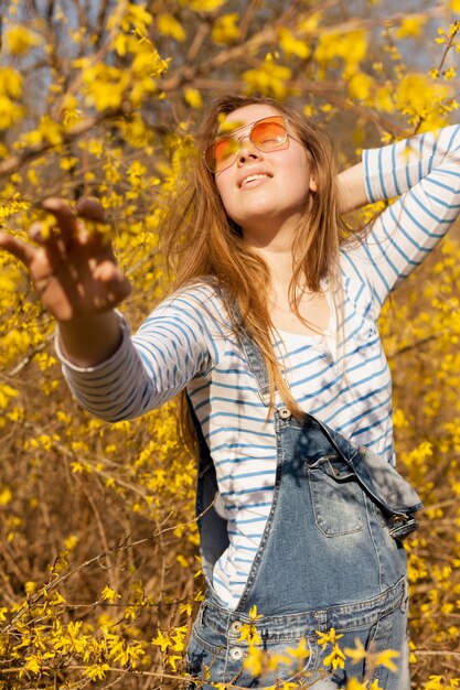 Carefree woman in nature posing in flower field