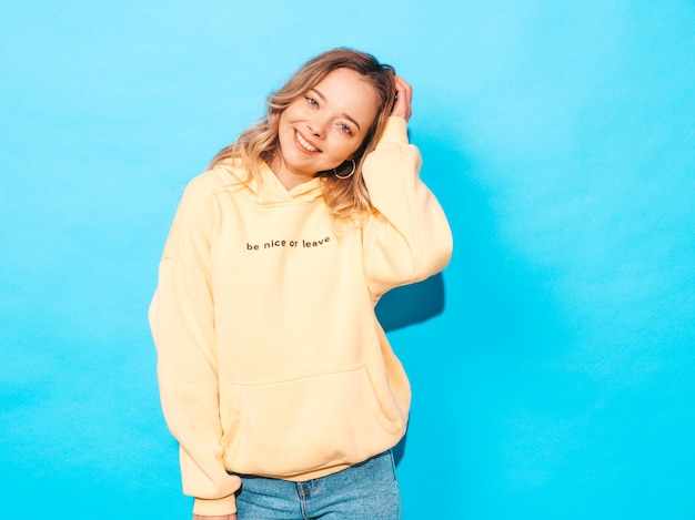 Free photo carefree woman posing near blue wall in studio. positive model having fun