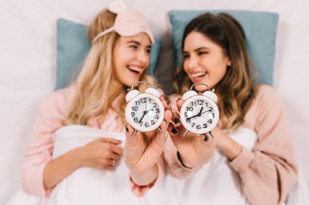 Carefree women lying in bed in evening