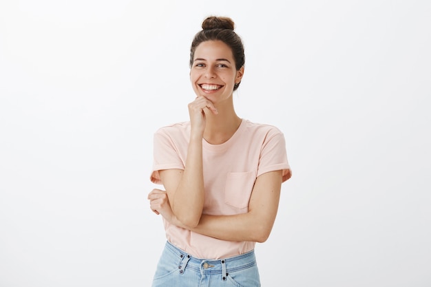 Carefree young stylish woman posing against the white wall