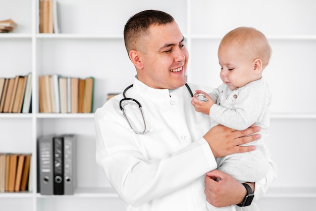 Careful doctor holding a lovely baby