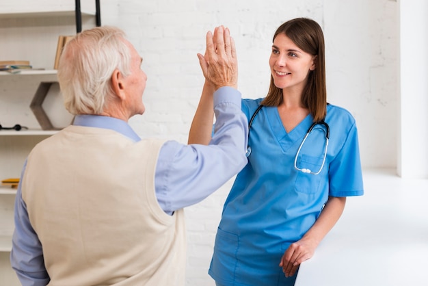 Free photo caregiver high fiving with old man