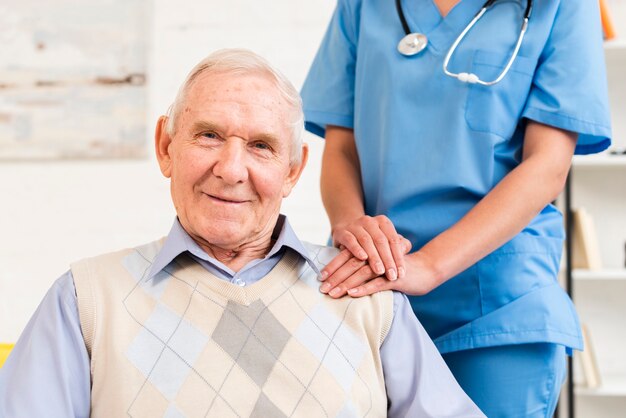 Caregiver holding old man's shoulder