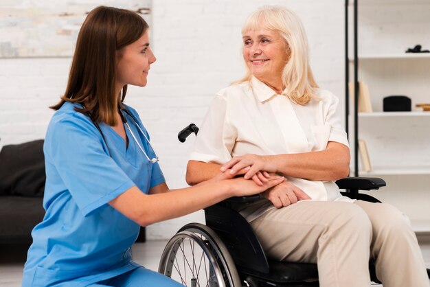 Caregiver taking care of woman in wheelchair