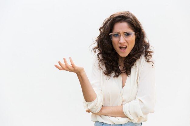 Careless puzzled woman in glasses shrugging