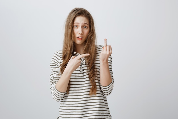 Careless rude girl showing middle finger at person