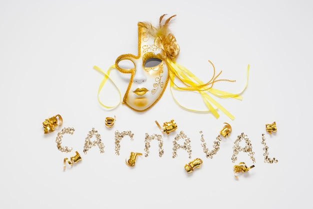 Carnival written in glitter and golden mask