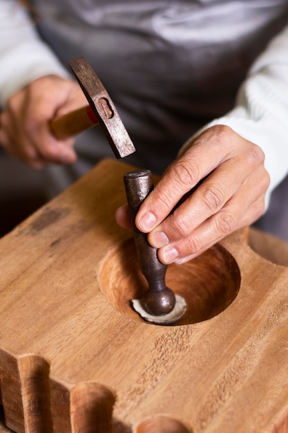 Carpenter creating a shape with hammer