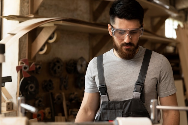 Free photo carpenter cutting mdf board inside workshop