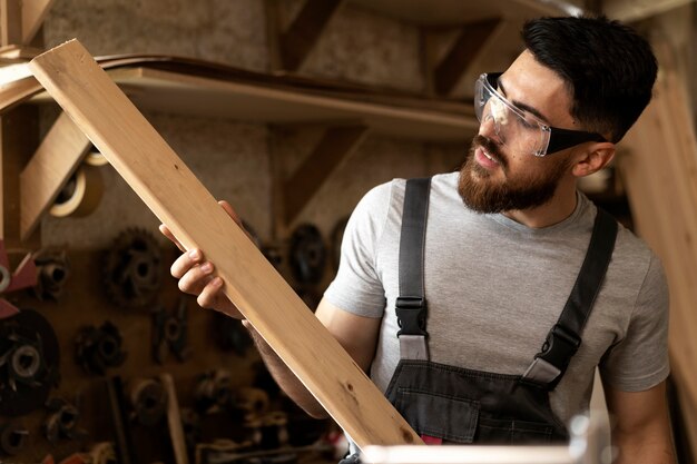 Carpenter cutting mdf board inside workshop