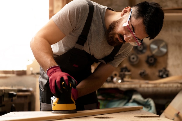 Free photo carpenter cutting mdf board inside workshop