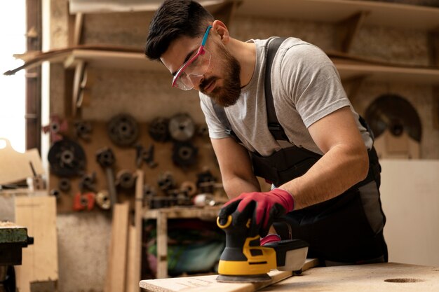 Carpenter cutting mdf board inside workshop