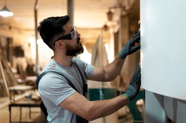 Free photo carpenter cutting mdf board inside workshop