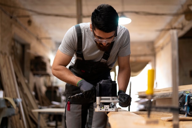 Free photo carpenter cutting mdf board inside workshop