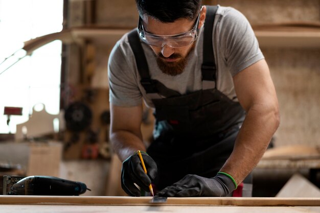 Carpenter cutting mdf board inside workshop