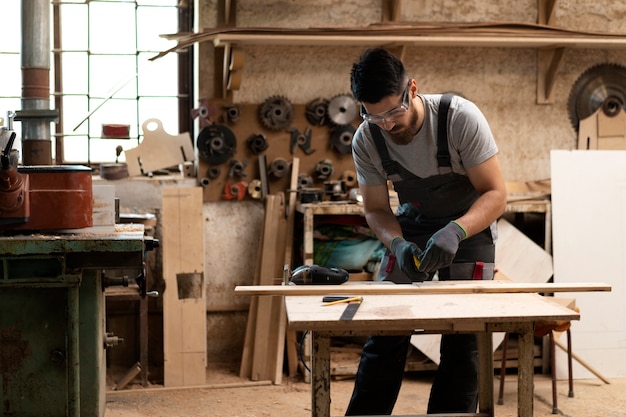 Carpenter cutting mdf board inside workshop