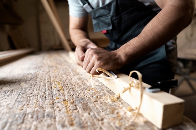 Carpenter cutting mdf board inside workshop