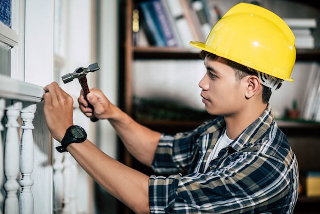 Free photo the carpenter holds the hammer and nails.