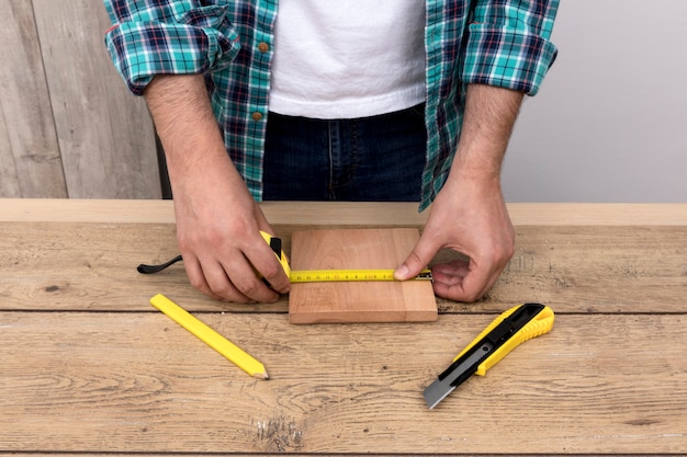 Foto gratuita uomo del carpentiere utilizzando righello e taglierina