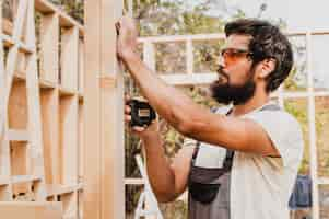 Free photo carpenter man using a tape measure