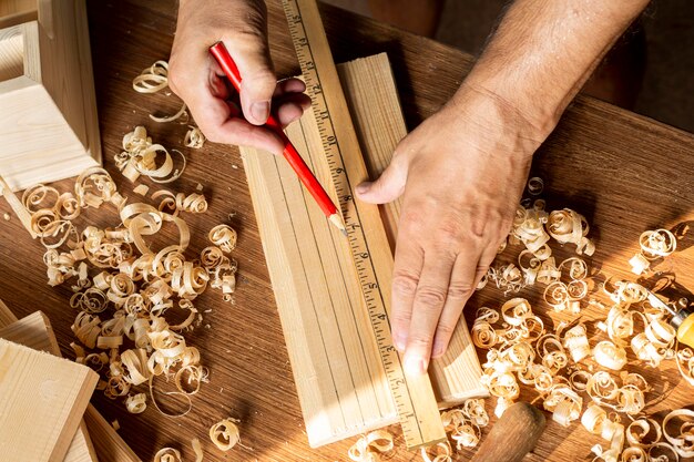 Carpenter measuring with ruler and pencil