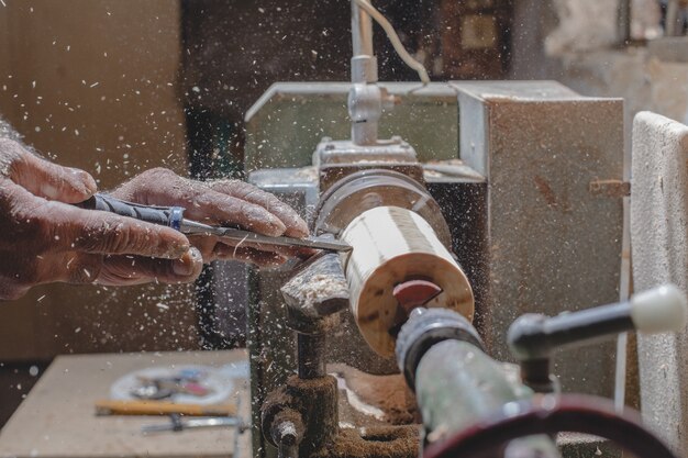 Плотник чистит деревянные детали, чтобы сделать фигурки