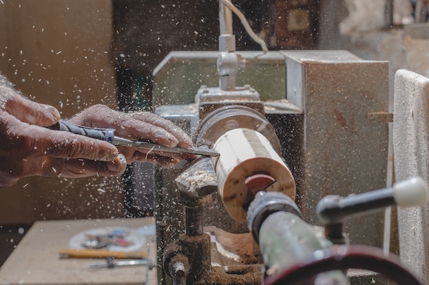 Carpenter peeling wooden pieces to make figures